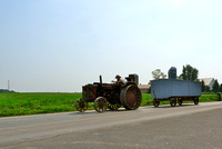 Steel-wheeled tractor hauling benching for a Sunday service